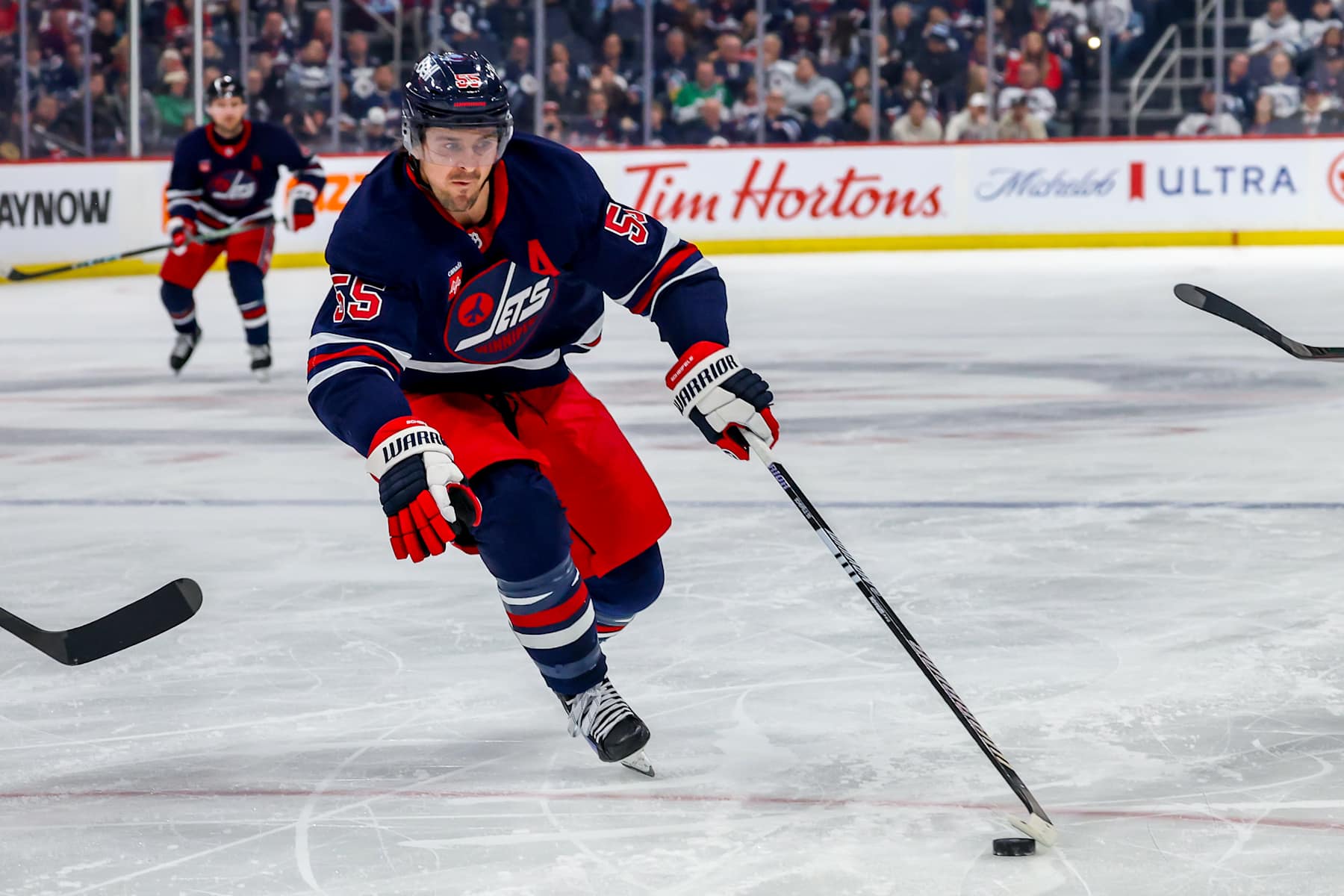 WINNIPEG, CANADA - FEBRUARY 04: Mark Scheifele #55 of the Winnipeg Jets plays the puck during second period action against the Carolina Hurricanes at Canada Life Centre on February 04, 2025 in Winnipeg, Manitoba, Canada. (Photo by Jonathan Kozub/NHLI via Getty Images)