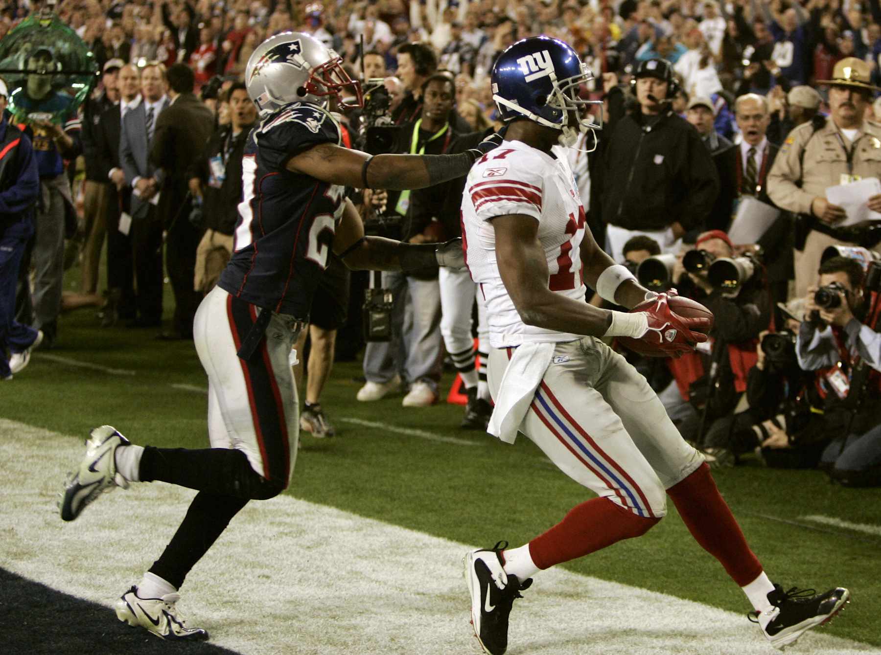 Plaxico Burress (R) of the New York Giants goes into the endzone against  Randall (L) Gay of the New England Patriots to score the winning touchdown in Super Bowl XLII at the University of Phoenix Stadium 03 February 2008 in Glendale, Arizona.  he New York Giants edged New England 17-14 in Super Bowl XLII, spoiling the previously undefeated Patriots' bid for a perfect National Football League championship season.   AFP PHOTO / Timothy A. CLARY (Photo credit should read TIMOTHY A. CLARY/AFP via Getty Images)