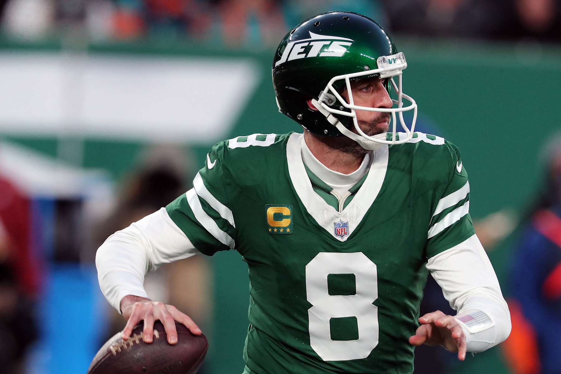 EAST RUTHERFORD, NEW JERSEY - JANUARY 5: Quarterback Aaron Rodgers #8 of the New York Jets rolls out to pass the ball in the game between the Miami Dolphins against the New York Jets at MetLife Stadium on January 5, 2025 in East Rutherford, New Jersey. (Photo by Al Pereira/Getty Images)