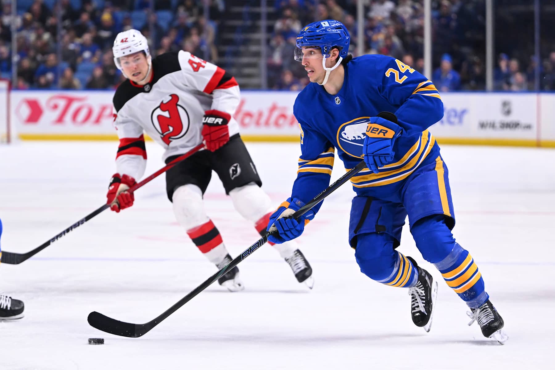 BUFFALO, NY - FEBRUARY 2: Dylan Cozens #24 of the Buffalo Sabres controls the puck against Curtis Lazar #42 of the New Jersey Devils during an NHL game on February 2, 2025 at KeyBank Center in Buffalo, New York. (Photo by Joe Hrycych/Getty Images)