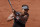 Japan's Naomi Osaka returns the ball to Romania's Patricia Maria Tig during their first round match of the French open tennis tournament at the Roland Garros stadium Sunday, May 30, 2021 in Paris. (AP Photo/Christophe Ena)