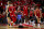 PISCATAWAY, NJ - DECEMBER 09:  Ron Harper Jr. #24 of the Rutgers Scarlet Knights lies on the court after sinking a three-point shot as teammates Paul Mulcahy #4, Mawot Mag #3 and Dean Reiber #21celebrate during the first half of a game at Jersey Mike's Arena on December 9, 2021 in Piscataway, New Jersey. (Photo by Rich Schultz/Getty Images)