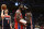 Philadelphia 76ers center Joel Embiid, center, reacts after he was fouled by Washington Wizards center Montrezl Harrell, right, during the second half of an NBA basketball game, Sunday, Dec. 26, 2021, in Washington. Wizards forward Deni Avdija is at left. The 76ers won 117-96. (AP Photo/Nick Wass)