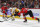 CHICAGO, ILLINOIS - DECEMBER 17: Rocco Grimaldi #23 of the Nashville Predators tries to control the puck between Caleb Jones #82 and Connor Murphy #5 of the Chicago Blackhawks at the United Center on December 17, 2021 in Chicago, Illinois. The Predators defeated the Blackhawks 3-2 in overtime. (Photo by Jonathan Daniel/Getty Images)