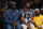 Los Angeles Lakers' LeBron James, Left, and Anthony Davis sit on the bench during the first half of an NBA basketball game against the Oklahoma City Thunder in Los Angeles, Friday, April 8, 2022. Neither played because of injury. (AP Photo/Ashley Landis)