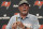 Outgoing Tampa Bay Buccaneers head coach Bruce Arians holds up a cigar during an NFL football intruoductory news conference for new head coach Todd Bowles Thursday, March 31, 2022, in Tampa, Fla. Arians is moving to the front office with the team. (AP Photo/Chris O'Meara)