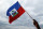 A man waves a Haitian flag at a campaign rally for presidential candidate Maryse Narcisse in Port-au-Prince, Haiti, Friday, Nov. 18, 2016. Sunday's voters will choose a new president, with the top two finishers going to a Jan. 29 runoff, as well as senators and members of the Chamber of Deputies. (AP Photo/Ricardo Arduengo)