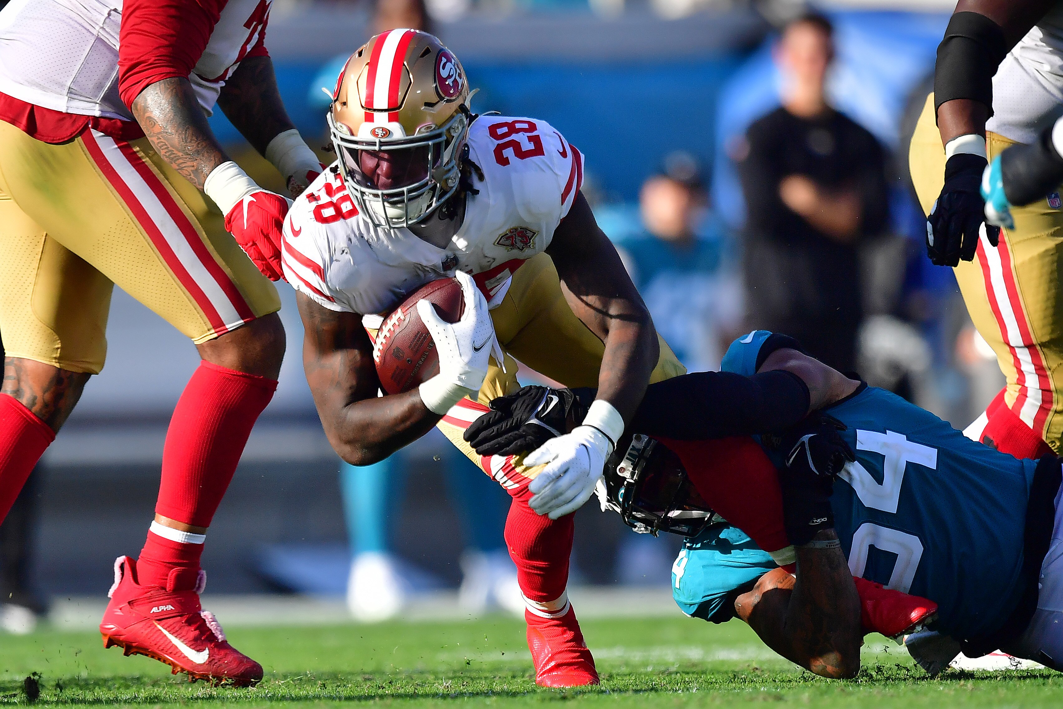 JACKSONVILLE, FLORIDA - NOVEMBER 21: Trey Sermon #28 of the San Francisco 49ers is tackled by Damien Wilson #54 of the Jacksonville Jaguars during the fourth quarter at TIAA Bank Field on November 21, 2021 in Jacksonville, Florida. (Photo by Julio Aguilar/Getty Images)