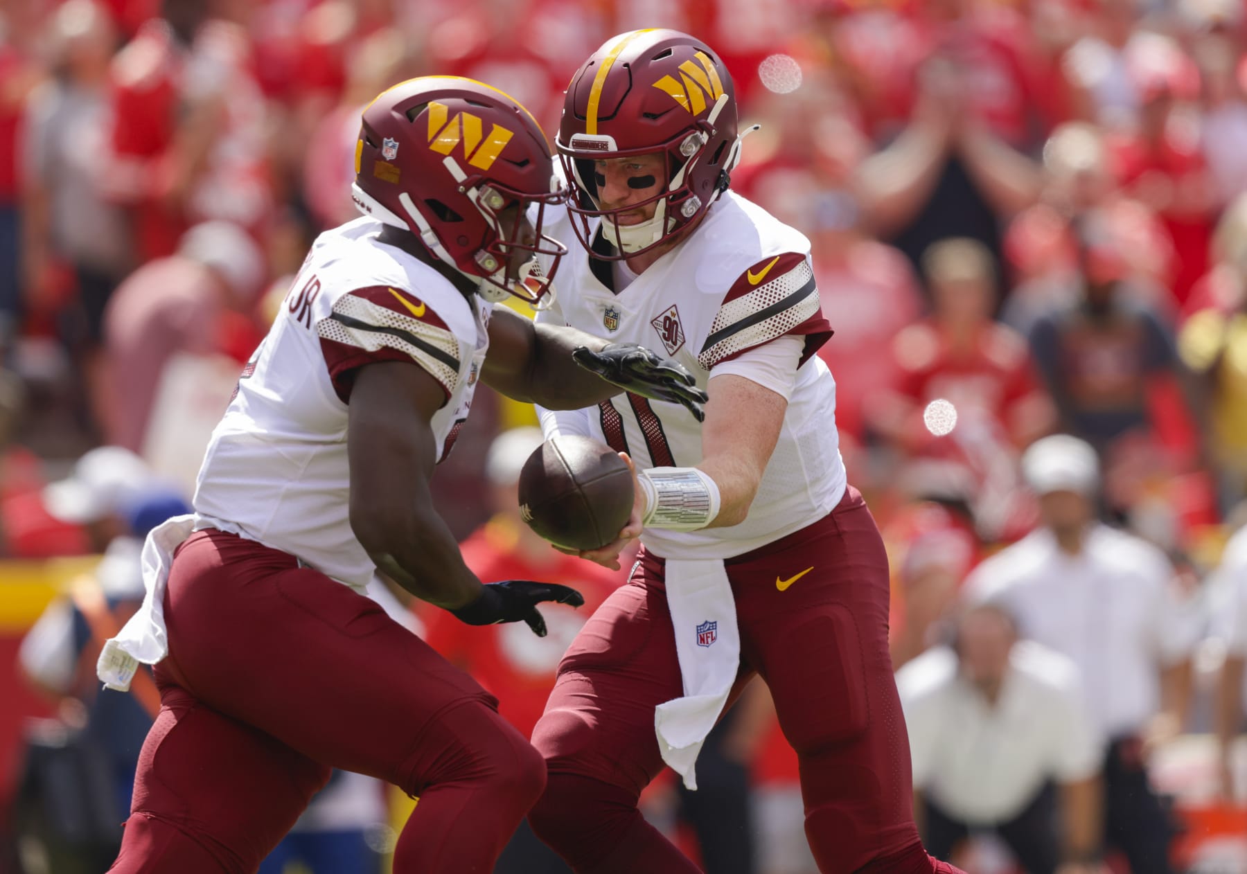 KANSAS CITY, MO - AUGUST 20: Carson Wentz #11 of the Washington Commanders hands the football to Brian Robinson #8 of the Washington Commanders during the first quarter against the Kansas City Chiefs at Arrowhead Stadium on August 20, 2022 in Kansas City, Missouri. (Photo by David Eulitt/Getty Images)