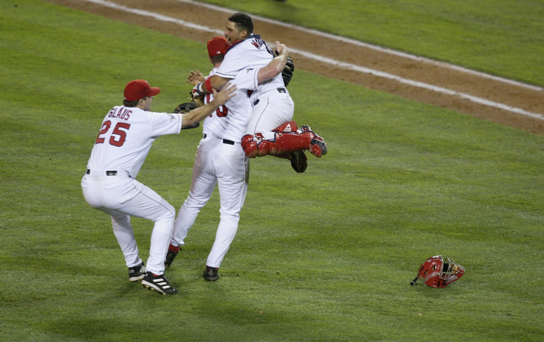 ANAHIM, CA - OCTOBER 27: Anaheim Angels #1 catcher Benji Molina jumps into the arms of closing pitcher Troy Percival #40 as they celebrate victory with teammate Troy Glaus #25 (left) at the end of their seventh World Series game against the San Francisco Giants in Edison Field in Anaheim, California on October 27, 2002. The Angels won the title against the Giants 4-1, in the franchise's first tournament in 42 years. (Photo by Donald Merale/Getty Images)