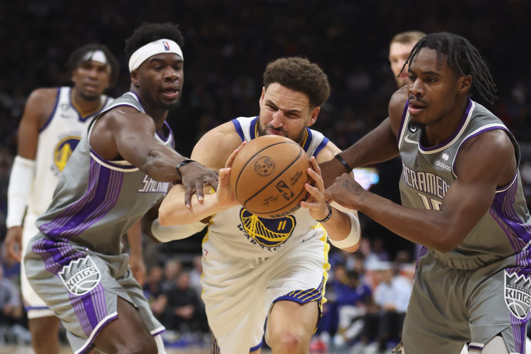 SACRAMENTO, CALIFORNIA - NOVEMBER 13: Klay Thompson #11 of the Golden State Warriors competes for the ball against Terence Davis #3 and Davion Mitchell #15 of the Sacramento Kings in the third quarter at Golden 1 Center on November 13, 2022 in Sacramento, California. NOTE TO USER: User expressly acknowledges and agrees that, by downloading and/or using this photograph, User is consenting to the terms and conditions of the Getty Images License Agreement. (Photo by Lachlan Cunningham/Getty Images)