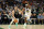 MILWAUKEE, WISCONSIN - DECEMBER 13: Grayson Allen #12 of the Milwaukee Bucks drives around Kevon Looney #5 of the Golden State Warriors during the first half of a game at Fiserv Forum on December 13, 2022 in Milwaukee, Wisconsin. NOTE TO USER: User expressly acknowledges and agrees that, by downloading and or using this photograph, User is consenting to the terms and conditions of the Getty Images License Agreement. (Photo by Stacy Revere/Getty Images)