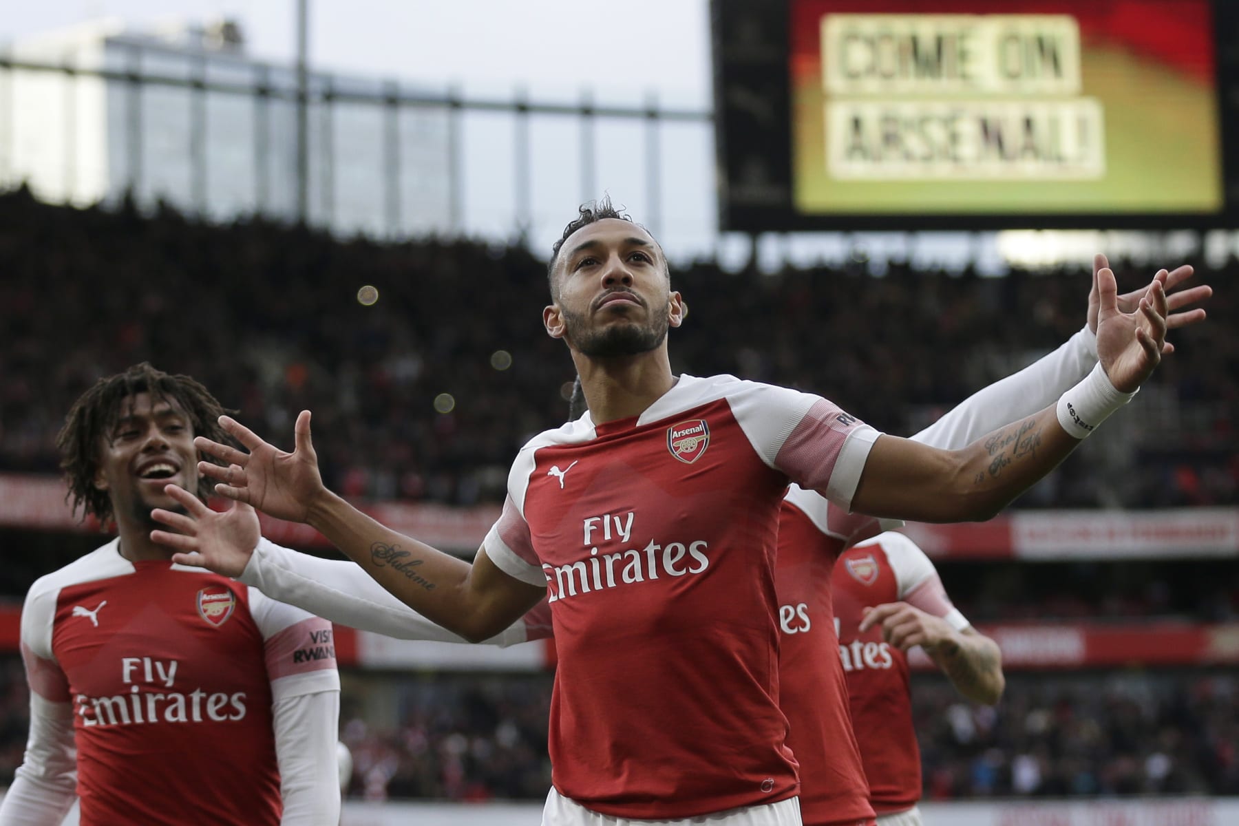 Arsenal's Pierre-Emerick Aubameyang celebrates with his teammates after scoring his side's opening goal from a penalty spot during the English Premier League soccer match between Arsenal and Tottenham Hotspur at the Emirates Stadium in London, Sunday Dec. 2, 2018. (AP Photo/Tim Ireland)