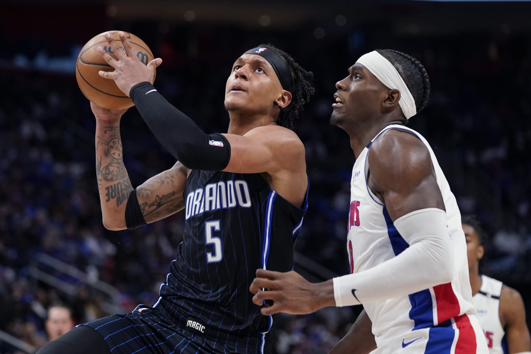 Orlando Magic forward Paolo Banchero (5) is defended by Detroit Pistons center Jalen Duren during the second half of an NBA basketball game, Wednesday, Oct. 19, 2022, in Detroit. (AP Photo/Carlos Osorio)