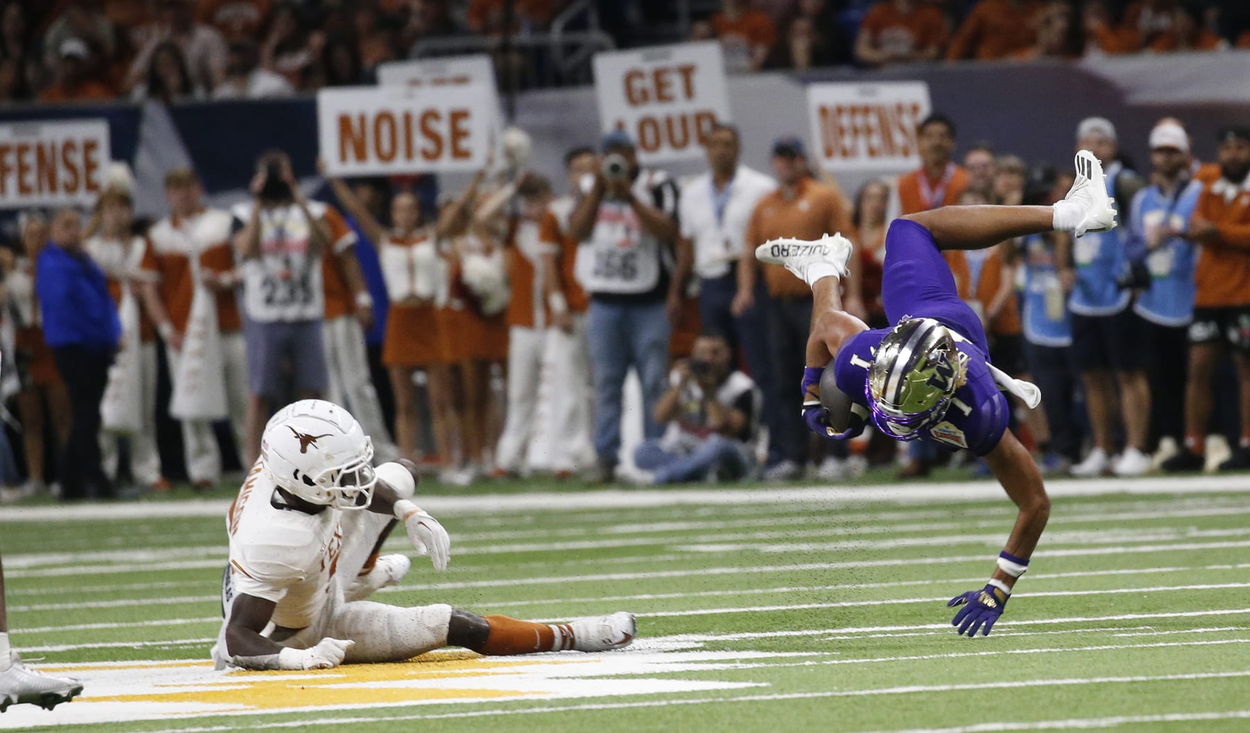 Football Football SAN ANTONIO, TX - DECEMBER 29: Rome Odunze #1 of the Washington Huskies is upended by DShawn Jamison #5 of the Texas Longhorns in the second half in the Valero Alamo Bowl at the Alamodome on December 29, 2022 in San Antonio, Texas. (Photo by Ronald Cortes/Getty Images)