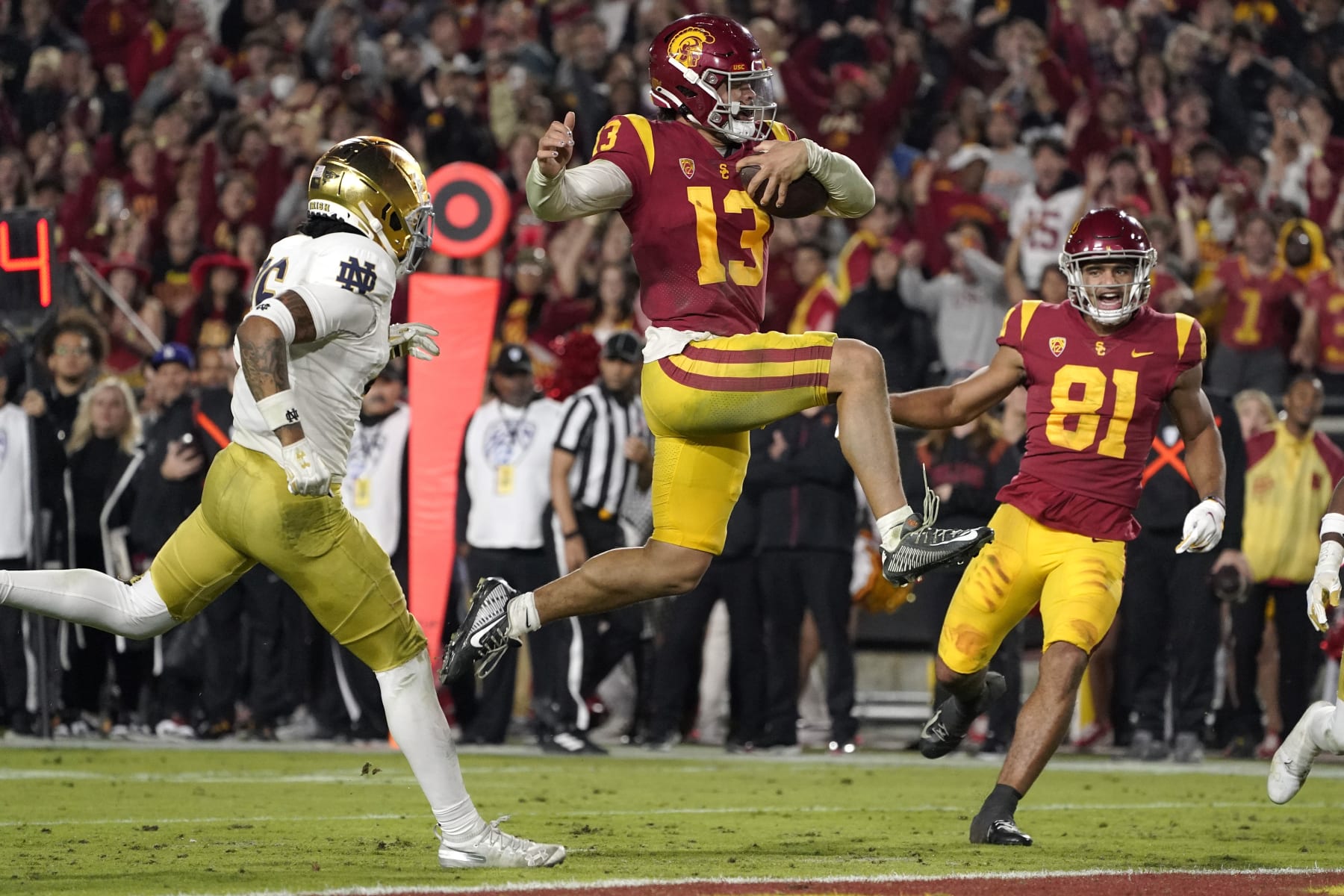 Football Football CORRECTS TO SECOND HALF, INSTEAD OF FIRST - Southern California quarterback Caleb Williams jumps in for a touchdown as Notre Dame safety Xavier Watts, left, defends and Southern California wide receiver Kyle Ford watches during the second half of an NCAA college football game Saturday, Nov. 26, 2022, in Los Angeles. (AP Photo/Mark J. Terrill)