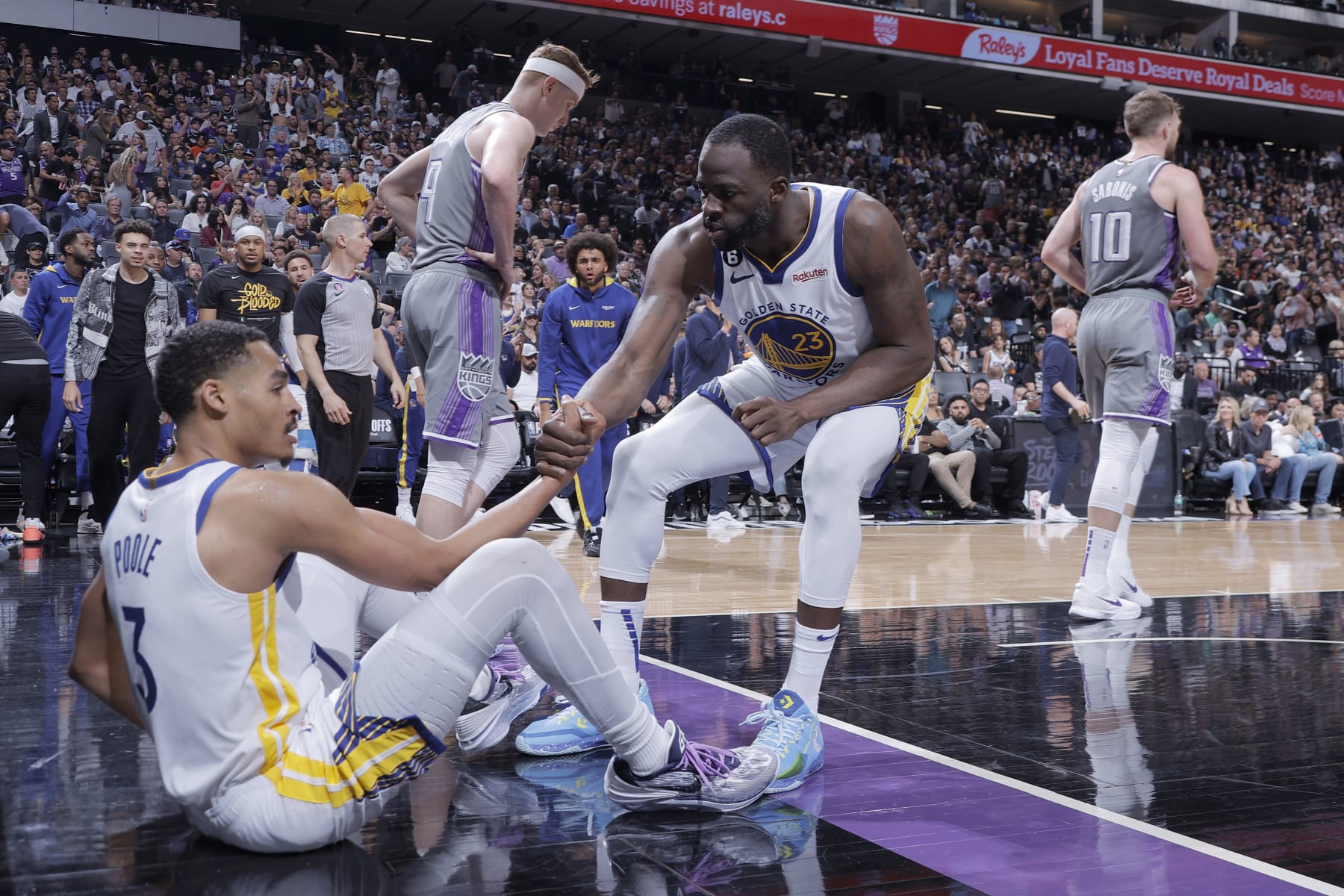 SACRAMENTO, CA - APRIL 26: Draymond Green #23 of the Golden State Warriors helps up Jordan Poole #3 during Round 1 Game 5 of the 2023 NBA Playoffs on April 26, 2023 at Golden 1 Center in SACRAMENTO, California. NOTE TO USER: User expressly acknowledges and agrees that, by downloading and or using this Photograph, user is consenting to the terms and conditions of the Getty Images License Agreement. Mandatory Copyright Notice: Copyright 2023 NBAE (Photo by Rocky Widner/NBAE via Getty Images)