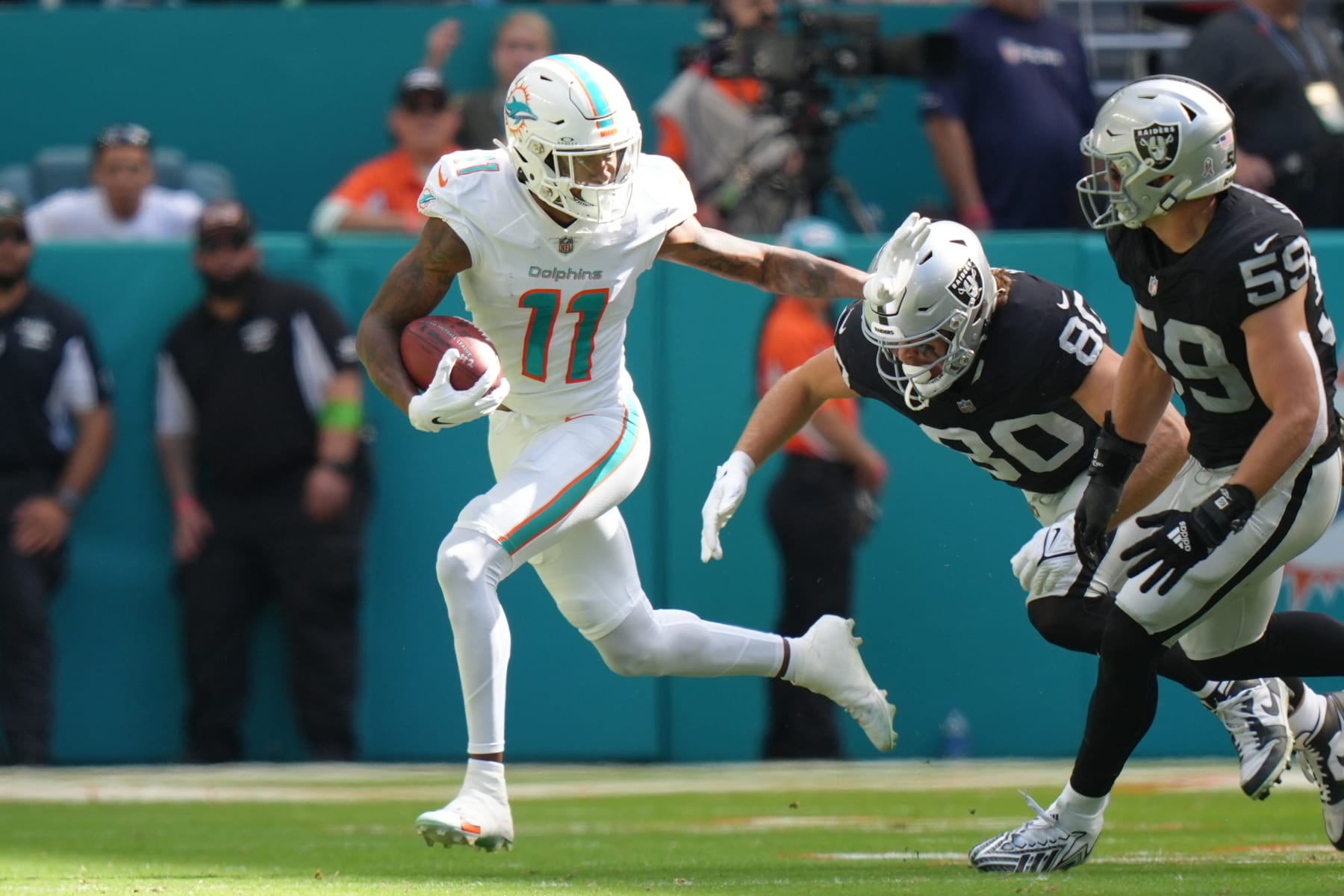 MIAMI GARDENS, FL - NOVEMBER 19: Miami Dolphins wide receiver Cedrick Wilson Jr. (11) tries to stiff arm Las Vegas Raiders tight end Jesper Horsted (80) during the game between the Las Vegas Raiders and the Miami Dolphins on Sunday, November 19, 2023 at Hard Rock Stadium, Miami, Fla. (Photo by Peter Joneleit/Icon Sportswire via Getty Images)