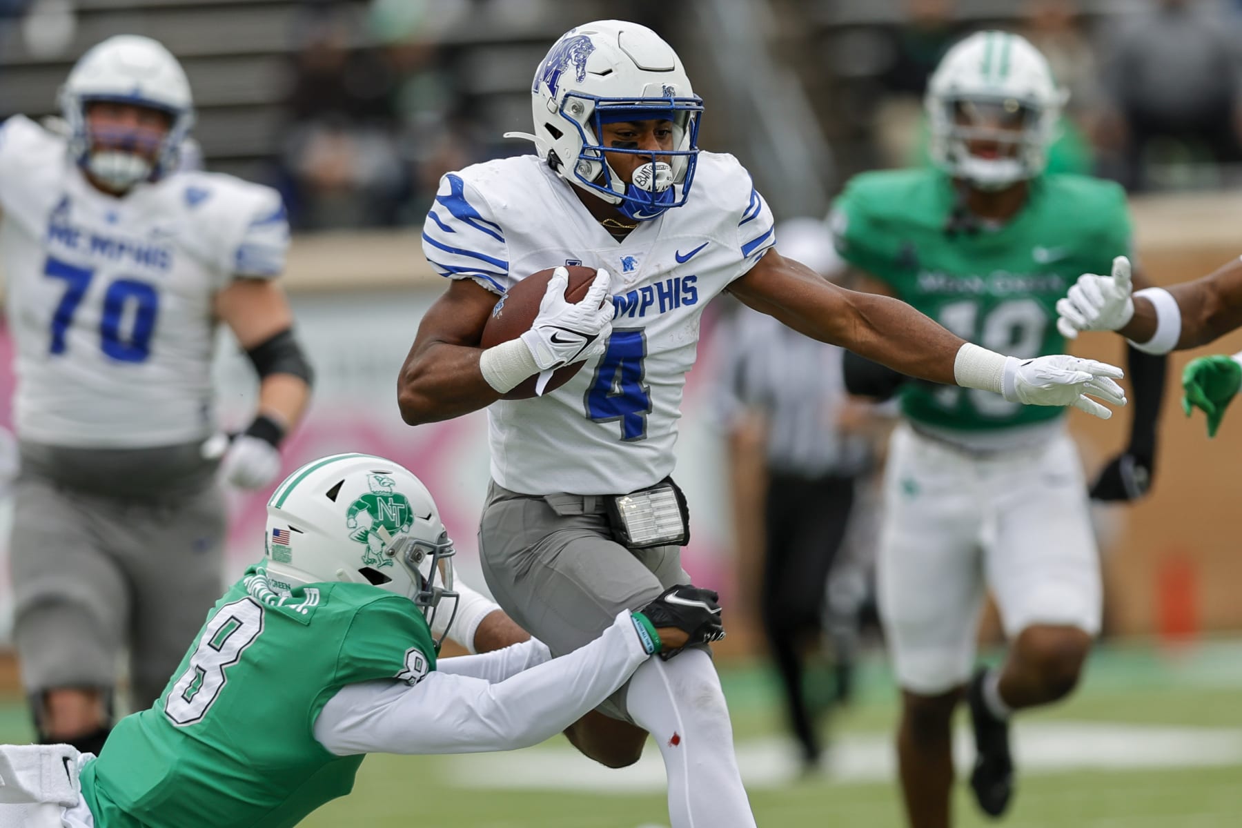 DENTON, TX - OCTOBER 28: Memphis Tigers running back Blake Watson (4) runs through North Texas Mean Green cornerback John Davis (8) during the game between the North Texas Mean Green and the Memphis Tigers on October 28, 2023 at DATCU Stadium in Denton, Texas. (Photo by Matthew Pearce/Icon Sportswire via Getty Images)