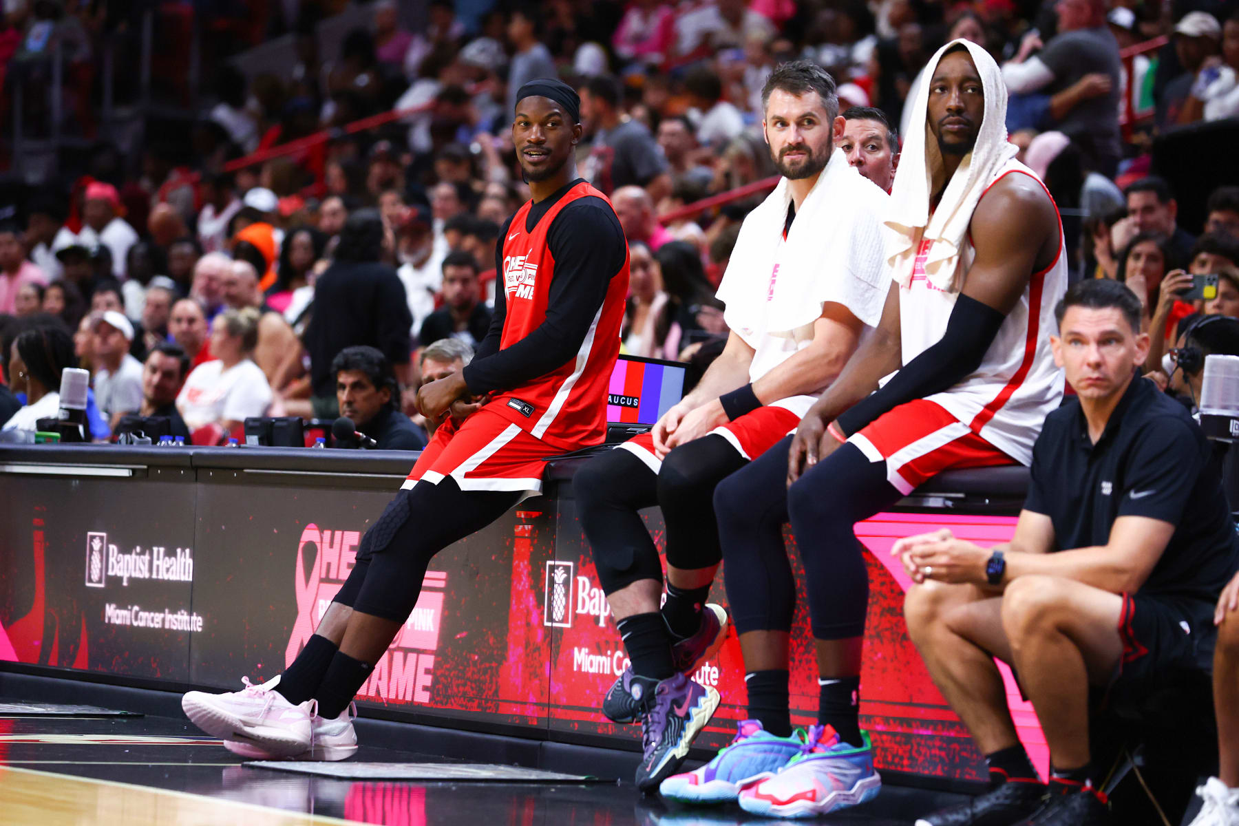 MIAMI, FLORIDA - OCTOBER 09: Jimmy Butler #22, Kevin Love #42 and Bam Adebayo #13 of the Miami Heat look on during the Miami Heat Red, White & Pink Game at Kaseya Center on October 09, 2023 in Miami, Florida. Proceeds from the game benefit cancer care and research at the Miami Cancer Institute at Baptist Health South Florida.  NOTE TO USER: User expressly acknowledges and agrees that, by downloading and or using this photograph, User is consenting to the terms and conditions of the Getty Images License Agreement. (Photo by Megan Briggs/Getty Images)