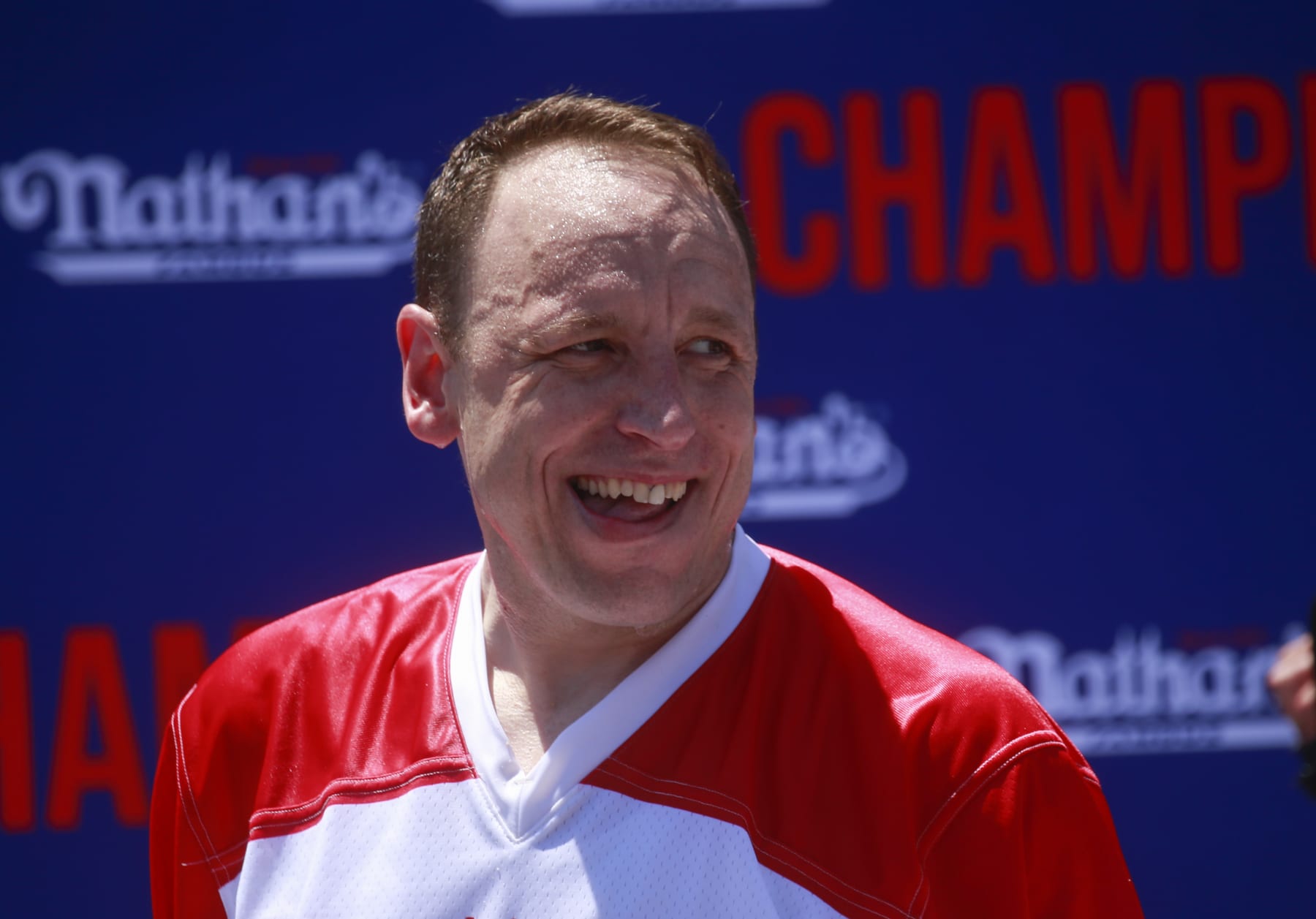 NEW YORK, NY - JULY 04: Joey Chestnut reacts after he won first place, eating 63 hot dogs in 10 minutes, during the 2022 Nathan's Famous Fourth of July International Hot Dog Eating Contest on July 4, 2022 at Coney Island in the Brooklyn borough of New York City. The contest, which has happened every year since 1972, has returned in front of Nathan's Famous on Surf Avenue this year. (Photo by Kena Betancur/Getty Images)