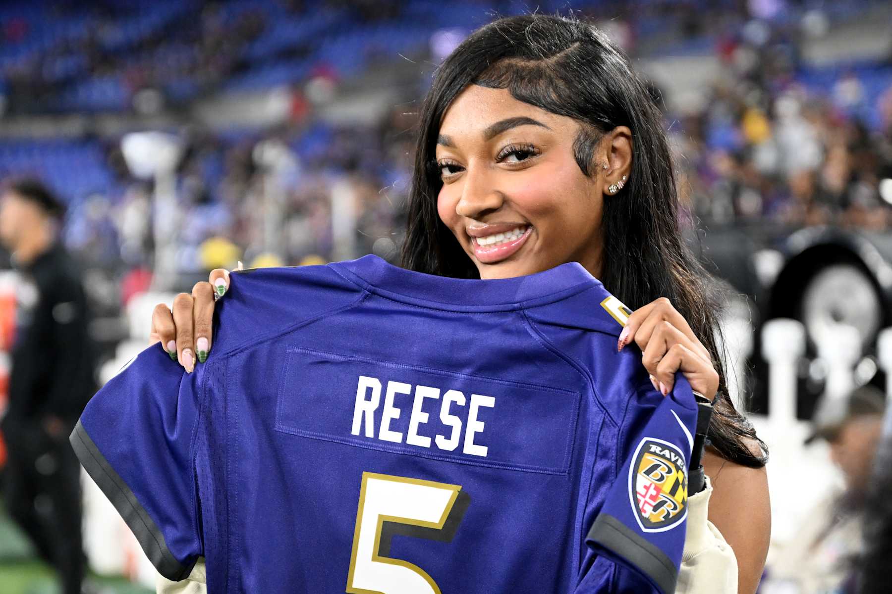 BALTIMORE, MARYLAND - SEPTEMBER 29: Angel Reese of the Chicago Sky holds a Baltimore Ravens jersey on the sidelines in the game between the against the Baltimore Ravens and the Buffalo Bills at M&T Bank Stadium on September 29, 2024 in Baltimore, Maryland. (Photo by Greg Fiume/Getty Images)