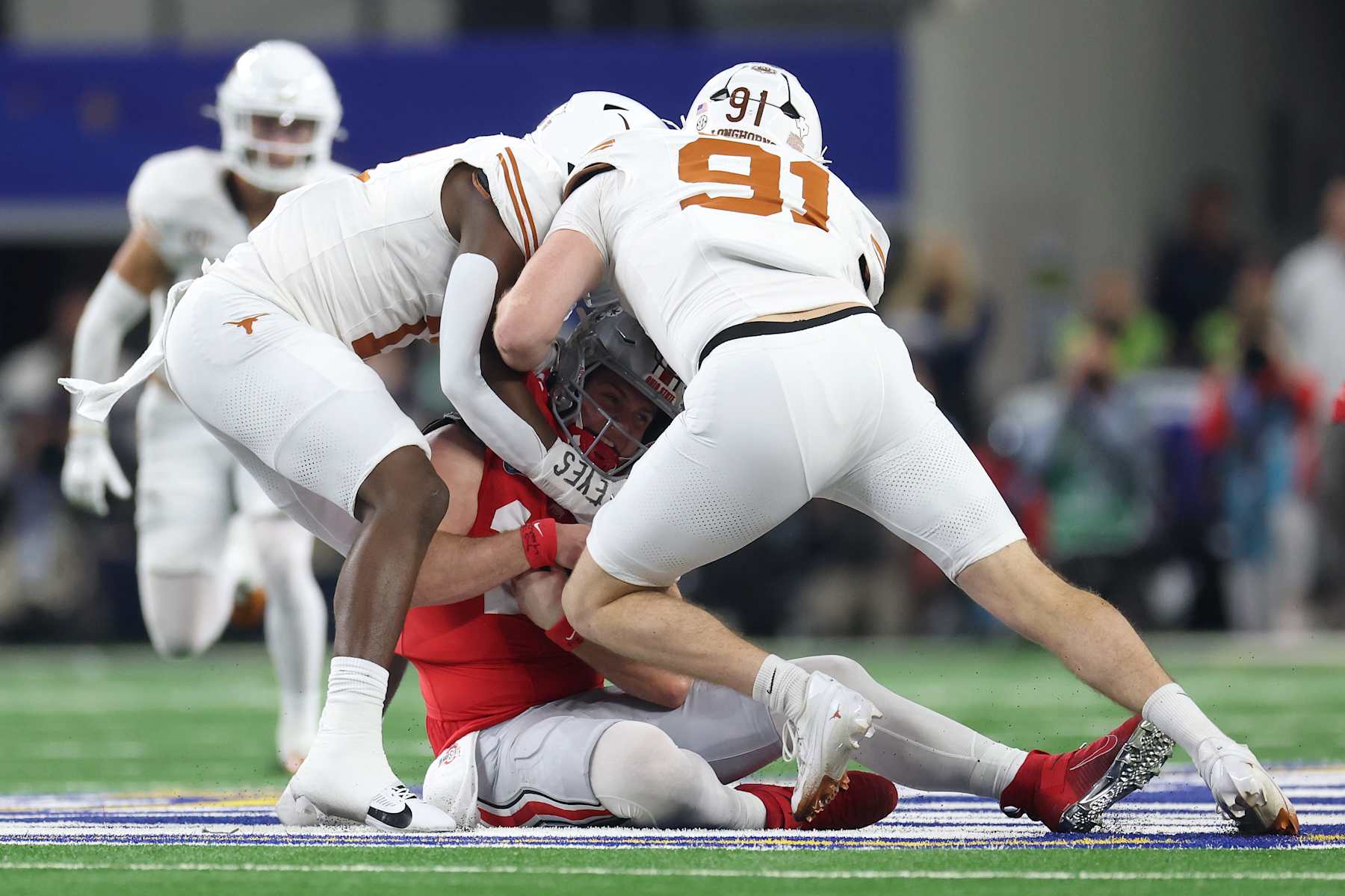 Football ARLINGTON, TEXAS - JANUARY 10: Colin Simmons #11 and Ethan Burke #91 of the Texas Longhorns sack Will Howard #18 of the Ohio State Buckeyes in the first quarter during the Goodyear Cotton Bowl at AT&T Stadium on January 10, 2025 in Arlington, Texas. (Photo by Jamie Squire/Getty Images)