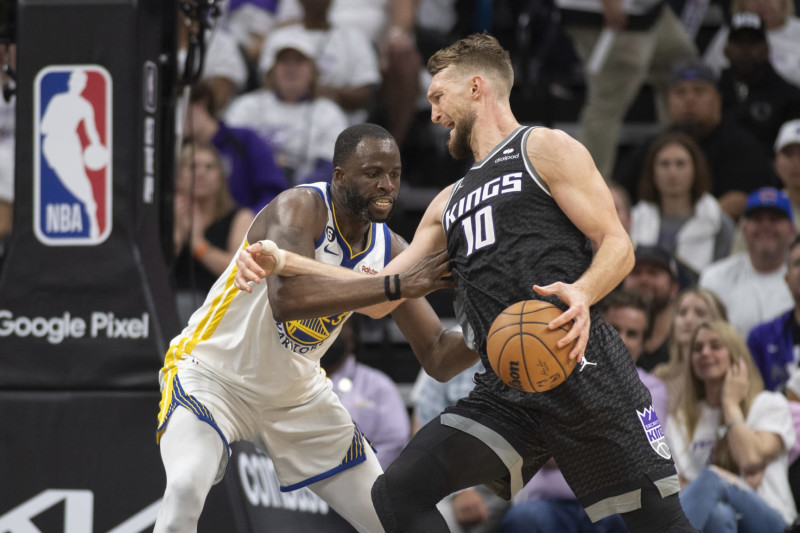 Golden State Warriors forward Draymond Green (23) defends Sacramento Kings forward Domantas Sabonis (10) in the fourth quarter during Game 1 in the first round of the NBA basketball playoffs in Sacramento, Calif., Saturday, April 15, 2023. The Kings won 126-123. (AP Photo/José Luis Villegas)