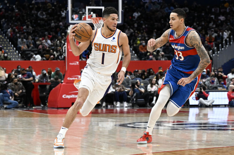 WASHINGTON, DC - FEBRUARY 05: Devin Booker #1 of the Phoenix Suns handles the ballin the third quarter against Kyle Kuzma #33 of the Washington Wizards at Capital One Arena on February 05, 2022 in Washington, DC. NOTE TO USER: User expressly acknowledges and agrees that, by downloading and or using this photograph, User is consenting to the terms and conditions of the Getty Images License Agreement.  (Photo by G Fiume/Getty Images)