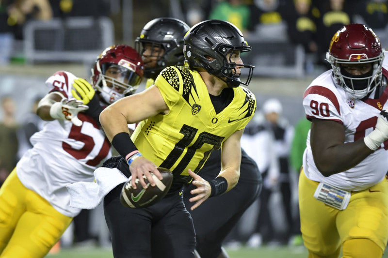 Oregon quarterback Bo Nix (10) scrambles against Southern California during the first half of an NCAA college football game Saturday, Nov. 11, 2023, in Eugene, Ore. (AP Photo/Andy Nelson)