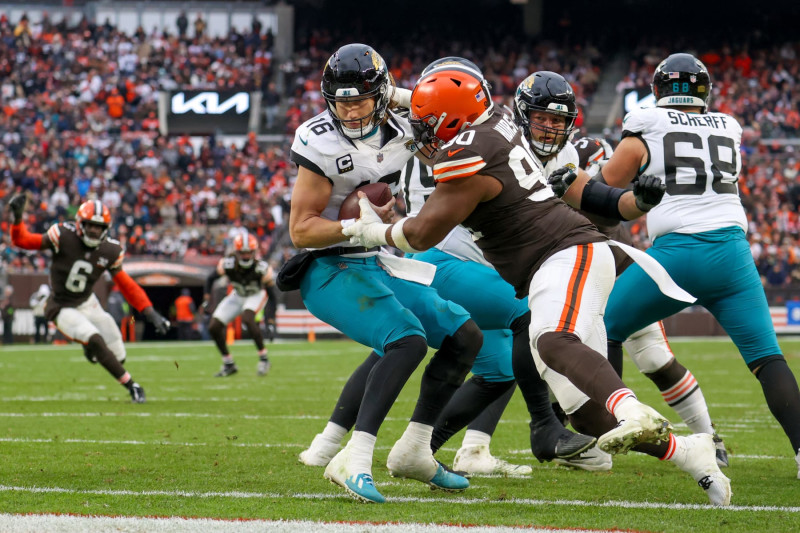 CLEVELAND, OH - DECEMBER 10: Jacksonville Jaguars quarterback Trevor Lawrence (16) eludes the rush of Cleveland Browns defensive tackle Maurice Hurst II (90) during the third quarter of the National Football League game between the Jacksonville Jaguars and Cleveland Browns on December 10, 2023, at Cleveland Browns Stadium in Cleveland, OH. (Photo by Frank Jansky/Icon Sportswire via Getty Images)