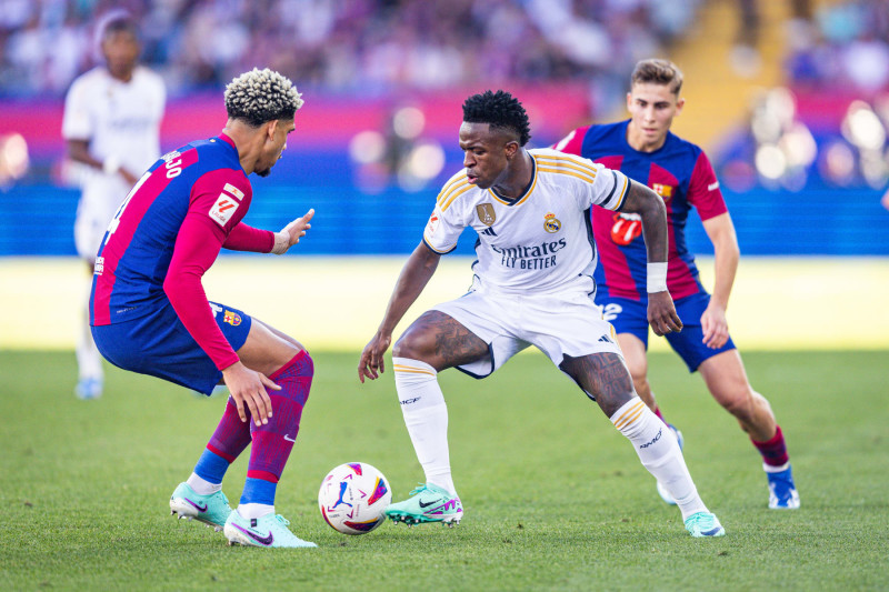 BARCELONA, SPAIN - 2023/10/28: Vinicius Junior (Real Madrid) (R) and Ronald Araujo (Barcelona) (L) in action during the football match of Spanish championship La Liga EA Sports between Barcelona vs Real Madrid, better known as El Clasico, played at Olimpico de Montjuic stadium. Final score: Barcelona 1 : 2 Real Madrid. (Photo by Alberto Gardin/SOPA Images/LightRocket via Getty Images)