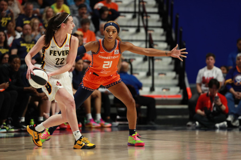 UNCASVILLE, CT - JUNE 10: DiJonai Carrington #21 of the Connecticut Sun plays defense against Caitlin Clark #22 of the Indiana Fever during the game on June 10, 2024 at the Mohegan Sun Arena in Uncasville, Connecticut. NOTE TO USER: User expressly acknowledges and agrees that, by downloading and or using this photograph, User is consenting to the terms and conditions of the Getty Images License Agreement. Mandatory Copyright Notice: Copyright 2024 NBAE (Photo by Chris Marion/NBAE via Getty Images)