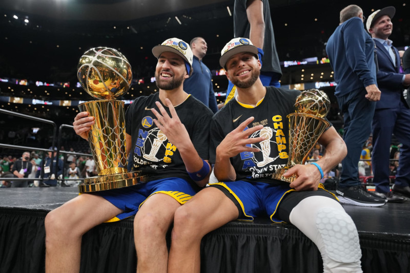 BOSTON, MA - JUNE 16:  Klay Thompson #11 and Stephen Curry #30 of the Golden State Warriors smile and celebrates on stage with The Larry O'Brien TrophyThe Bill Russell Finals MVP Trophy after winning during Game Six of the 2022 NBA Finals on June 16, 2022 at TD Garden in Boston, Massachusetts. NOTE TO USER: User expressly acknowledges and agrees that, by downloading and or using this photograph, user is consenting to the terms and conditions of Getty Images License Agreement. Mandatory Copyright Notice: Copyright 2022 NBAE (Photo by Jesse D. Garrabrant/NBAE via Getty Images)