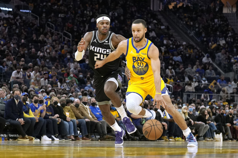 SAN FRANCISCO, CALIFORNIA - DECEMBER 20: Stephen Curry #30 of the Golden State Warriors drives on Buddy Hield #24 of the Sacramento Kings during the third quarter at Chase Center on December 20, 2021 in San Francisco, California. NOTE TO USER: User expressly acknowledges and agrees that, by downloading and or using this photograph, User is consenting to the terms and conditions of the Getty Images License Agreement. (Photo by Thearon W. Henderson/Getty Images)