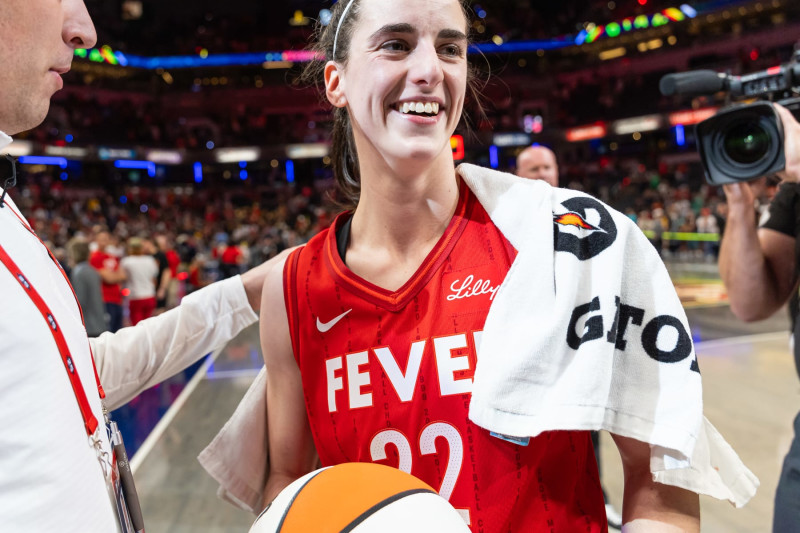 INDIANAPOLIS, INDIANA - JULY 6: Caitlin Clark #22 of the Indiana Fever is presented the game ball after becoming the first rookie to score a triple double against the New York Liberty at Gainbridge Fieldhouse on July 6, 2024 in Indianapolis, Indiana. NOTE TO USER: User expressly acknowledges and agrees that, by downloading and or using this photograph, User is consenting to the terms and conditions of the Getty Images License Agreement. (Photo by Michael Hickey/Getty Images)