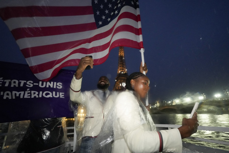 TOPSHOT - United States' Coco Gauff and Lebron James take photos as they travel along the Seine River in Paris, France, during the opening ceremony of the 2024 Summer Olympics, Friday, July 26, 2024. (Photo by Ashley Landis / POOL / AFP) (Photo by ASHLEY LANDIS/POOL/AFP via Getty Images)