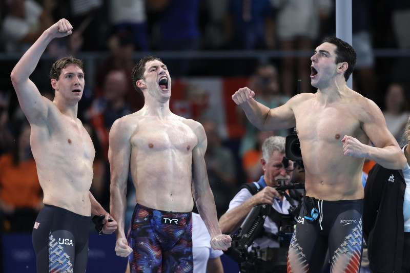 Chris Guiliano, Hunter Armstrong and Jack Alexy celebrate after Caeleb Dressel finishes the anchor of the 4x100 freestyle relay in first place. 