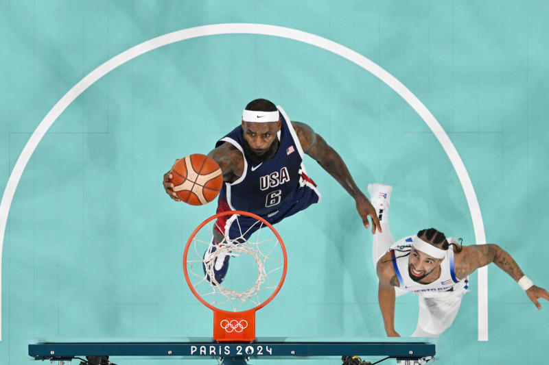 LILLE, FRANCE - AUGUST 03: (EDITORS NOTE: Image was captured using a remote camera positioned above the field of play) Lebron James #6 of Team United States goes up for a basket past Jose Alvarado #10 of Team Puerto Rico during a Men's basketball group phase-group C game between the United States and Puerto Rico on day eight of the Olympic Games Paris 2024 at Stade Pierre Mauroy on August 03, 2024 in Lille, France. (Photo by Pool/Getty Images)