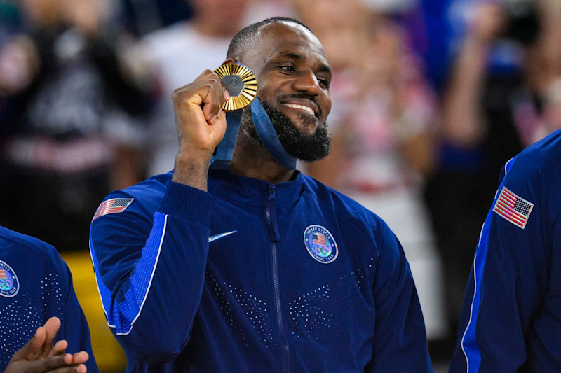 PARIS, FRANCE - AUGUST 11: Gold medalist LeBron James of Team United States celebrate on the podium during the Men's basketball medal ceremony on day fifteen of the Olympic Games Paris 2024 at the Bercy Arena on August 11, 2024 in Paris, France. (Photo by Tom Weller/VOIGT/GettyImages)