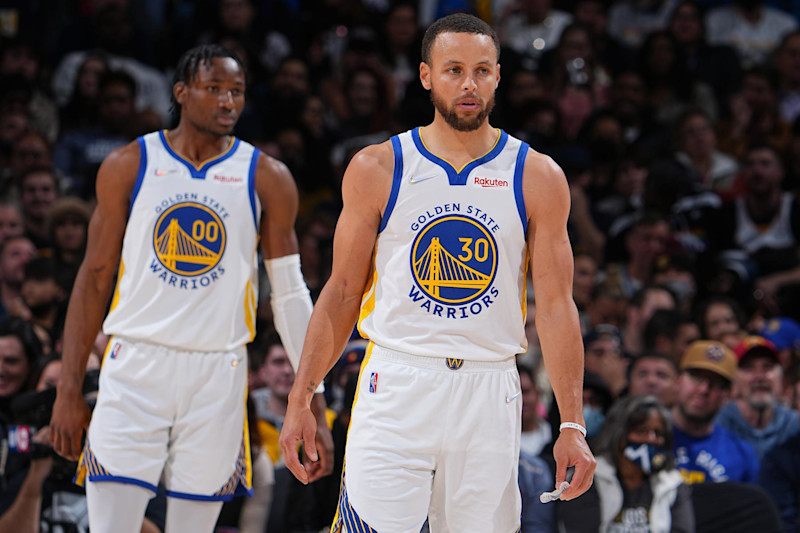 DENVER, CO - MARCH 10: Jonathan Kuminga #00 and Stephen Curry #30 of the Golden State Warriors look on during the game against the Denver Nuggets on March 10, 2022 at the Ball Arena in Denver, Colorado. NOTE TO USER: User expressly acknowledges and agrees that, by downloading and/or using this Photograph, user is consenting to the terms and conditions of the Getty Images License Agreement. Mandatory Copyright Notice: Copyright 2022 NBAE (Photo by Bart Young/NBAE via Getty Images)