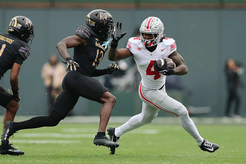 CHICAGO, ILLINOIS - NOVEMBER 16: Jeremiah Smith #4 of the Ohio State Buckeyes stiff arms Josh Fussell #13 of the Northwestern Wildcats after a reception during the first half at Wrigley Field on November 16, 2024 in Chicago, Illinois. (Photo by Michael Reaves/Getty Images)