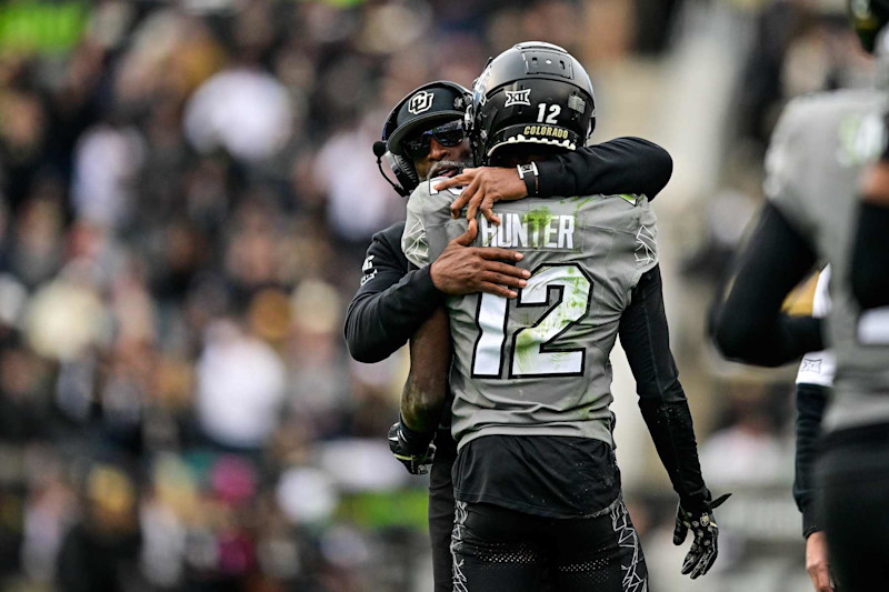 BOULDER, CO - NOVEMBER 16:  Travis Hunter #12 of the Colorado Buffaloes celebrates with head coach Deion Sanders after scoring a fourth quarter touchdown against the Utah Utes at Folsom Field on November 16, 2024 in Boulder, Colorado. (Photo by Dustin Bradford/Getty Images)