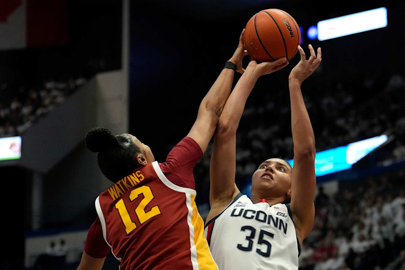 HARTFORD, CONNECTICUT - DECEMBER 21: Azzi Fudd #35 of the Connecticut Huskies is blocked by JuJu Watkins #12 of the USC Trojans during the first half of an NCAA women's basketball game at the XL Center on December 21, 2024 in Hartford, Connecticut. (Photo by Joe Buglewicz/Getty Images)