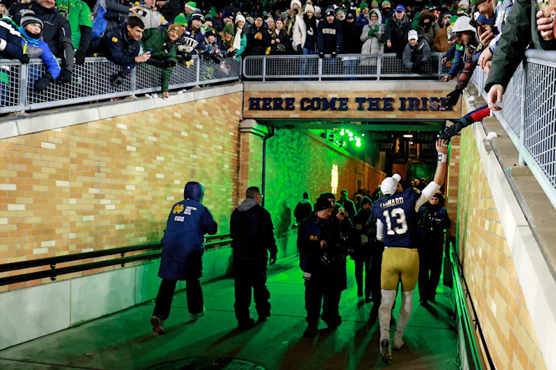 SOUTH BEND, IN - DECEMBER 20: Notre Dame Fighting Irish quarterback Riley Leonard (13) high fives fans as he walks through the tunnel to the locker room after the game against the Indiana Hoosiers on December 20, 2024, during the CFP First Round playoff game at Notre Dame Stadium in South Bend, Indiana. (Photo by Brian Spurlock/Icon Sportswire via Getty Images)