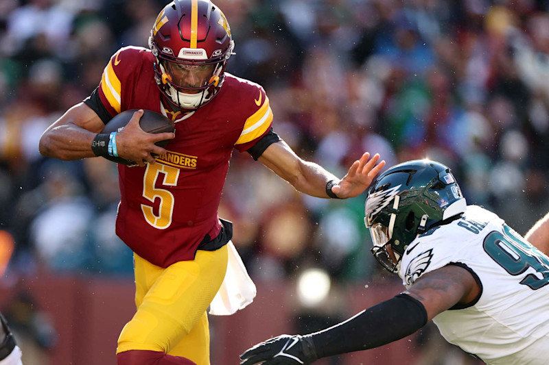 LANDOVER, MARYLAND - DECEMBER 22:  Jayden Daniels #5 of the Washington Commanders runs the ball against Jalen Carter #98 of the Philadelphia Eagles during the first quarter at Northwest Stadium on December 22, 2024 in Landover, Maryland. (Photo by Scott Taetsch/Getty Images)