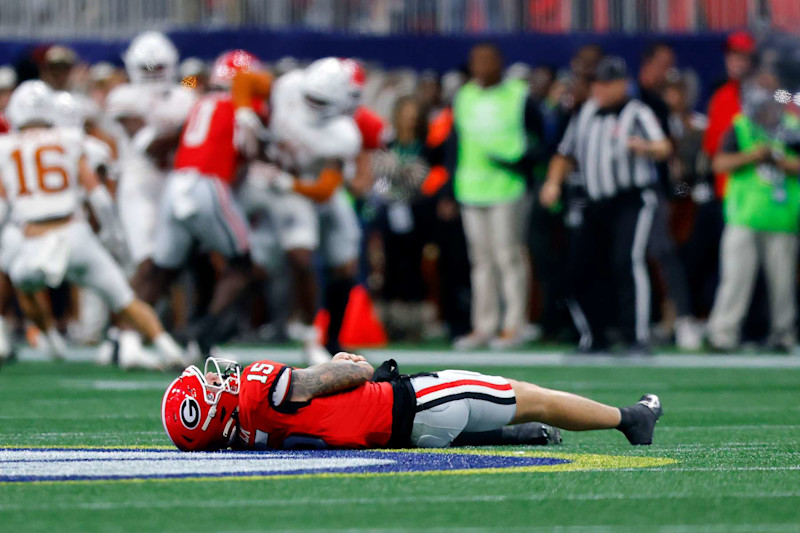 ATLANTA, GEORGIA - DECEMBER 07: Carson Beck #15 of the Georgia Bulldogs lays on the ground after an injury against the Texas Longhorns during the second quarter of the 2024 SEC Championship at Mercedes-Benz Stadium on December 07, 2024 in Atlanta, Georgia. (Photo by Todd Kirkland/Getty Images)