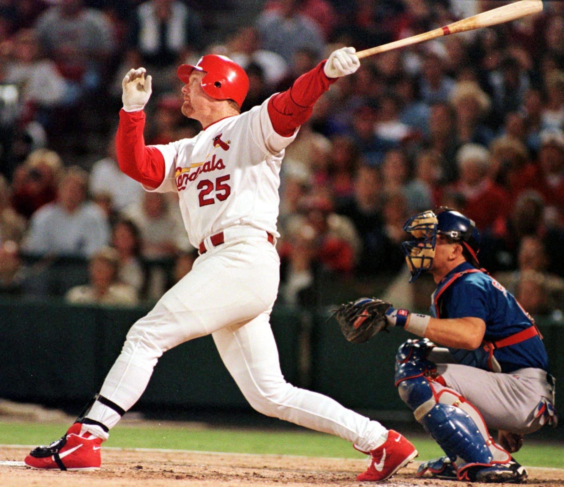 ST. LOUIS, MO - OCTOBER 1:  St. Louis Cardinals' first baseman Mark McGwire (L) watches as the ball flies out in the fourth inning with Chicago Cubs' catcher Benito Santiago looking on in St. Louis, Missouri 01 October 1999 .  McGwire stayed at 63 home runs and Sosa stayed at 62 as neither had a home run in the 3-2 Chicago victory.  (Photo credit should read PETER NEWCOMB/AFP via Getty Images)