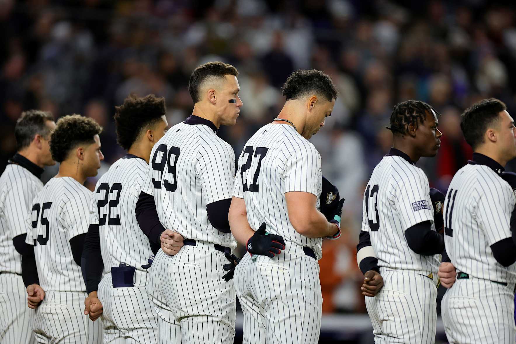 NEW YORK, NEW YORK - OCTOBER 28: Aaron Judge #99 and Giancarlo Stanton #27 of the New York Yankees look on during the national anthem prior to playing the Los Angeles Dodgers during Game Three of the 2024 World Series at Yankee Stadium on October 28, 2024 in the Bronx borough of New York City. (Photo by Alex Slitz/Getty Images)