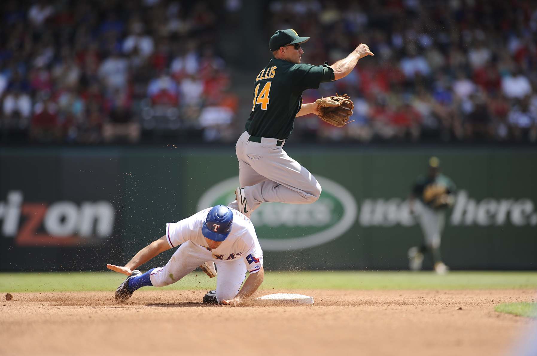 ARLINGTON, TX - AUGUST 29: Second baseman Mark Ellis #14 of the Oakland Athletics fields his position as he throws to first base to complete a double play while avoiding the sliding baserunner during the game against the Texas Rangers at the Rangers Ballpark in Arlington, Texas on Sunday, August 29, 2010. The Athletics defeated the Rangers 8-2. (Photo by John Williamson/MLB Photos via Getty Images)